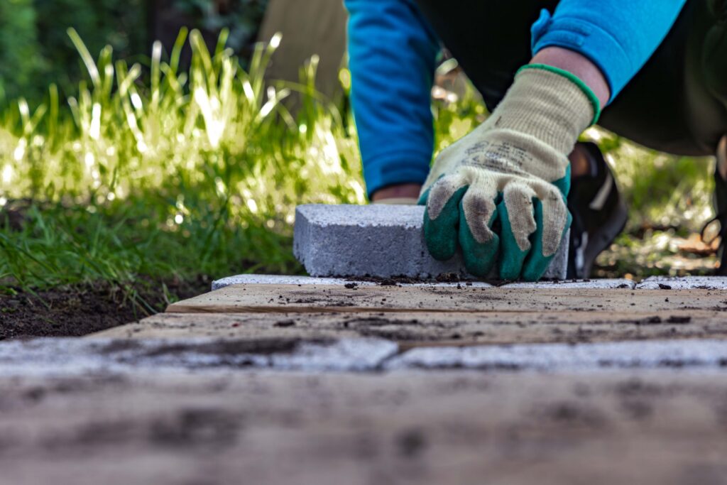 Pose de pierres de granite dans un jardin lors de travaux d'aménagement extérieur au printemps